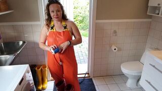 Horny MILF dressing up in rainpants - oiling huge tits